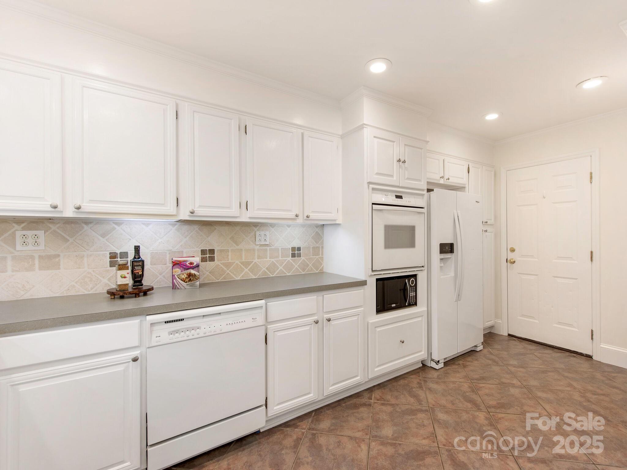 1422 Burnley Road Charlotte, NC 28210 - Photo 12 of 29 a kitchen with granite countertop white cabinets and white appliances