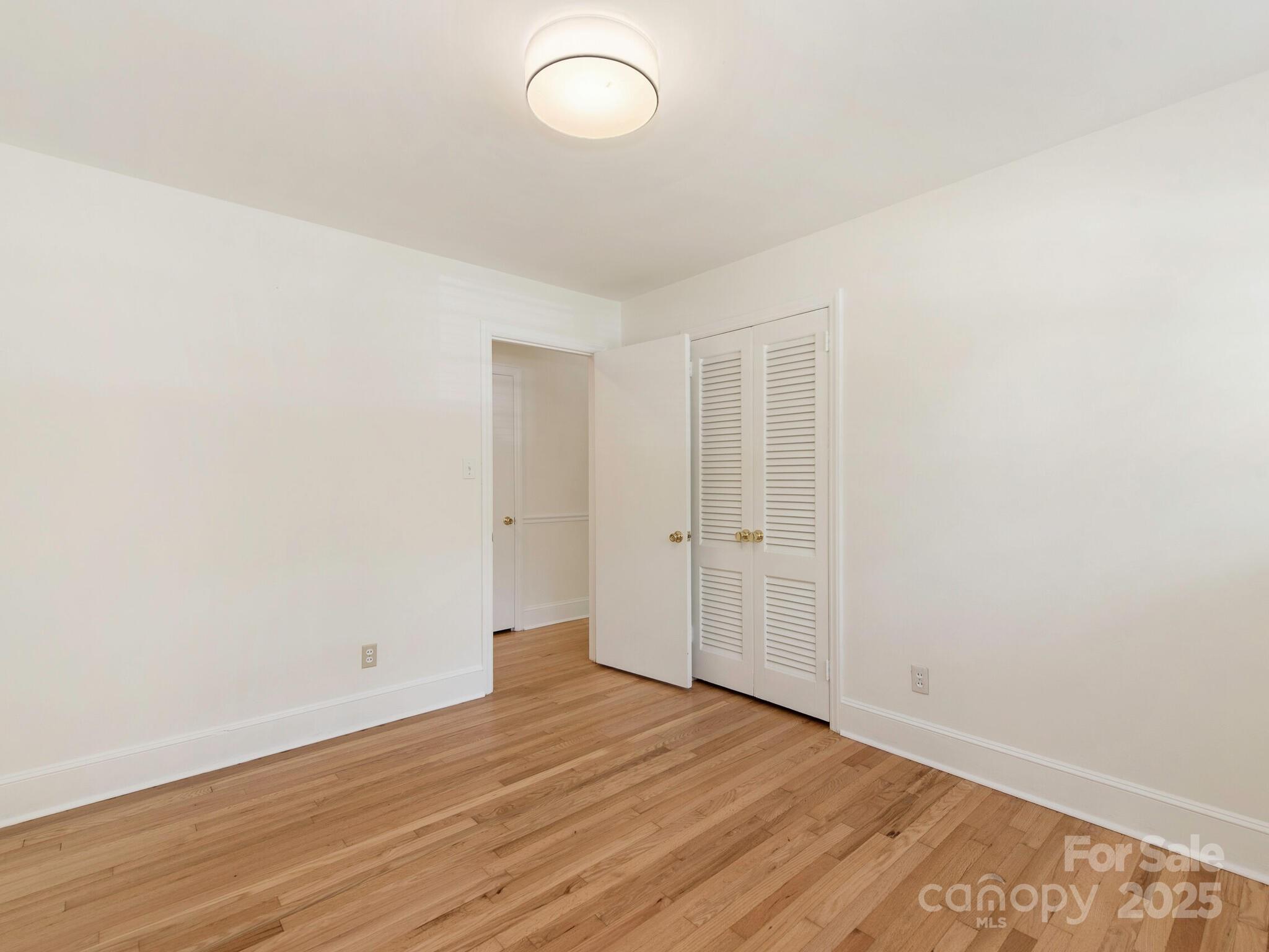 1422 Burnley Road Charlotte, NC 28210 - Photo 14 of 29 a view of a room with wooden floor and white walls