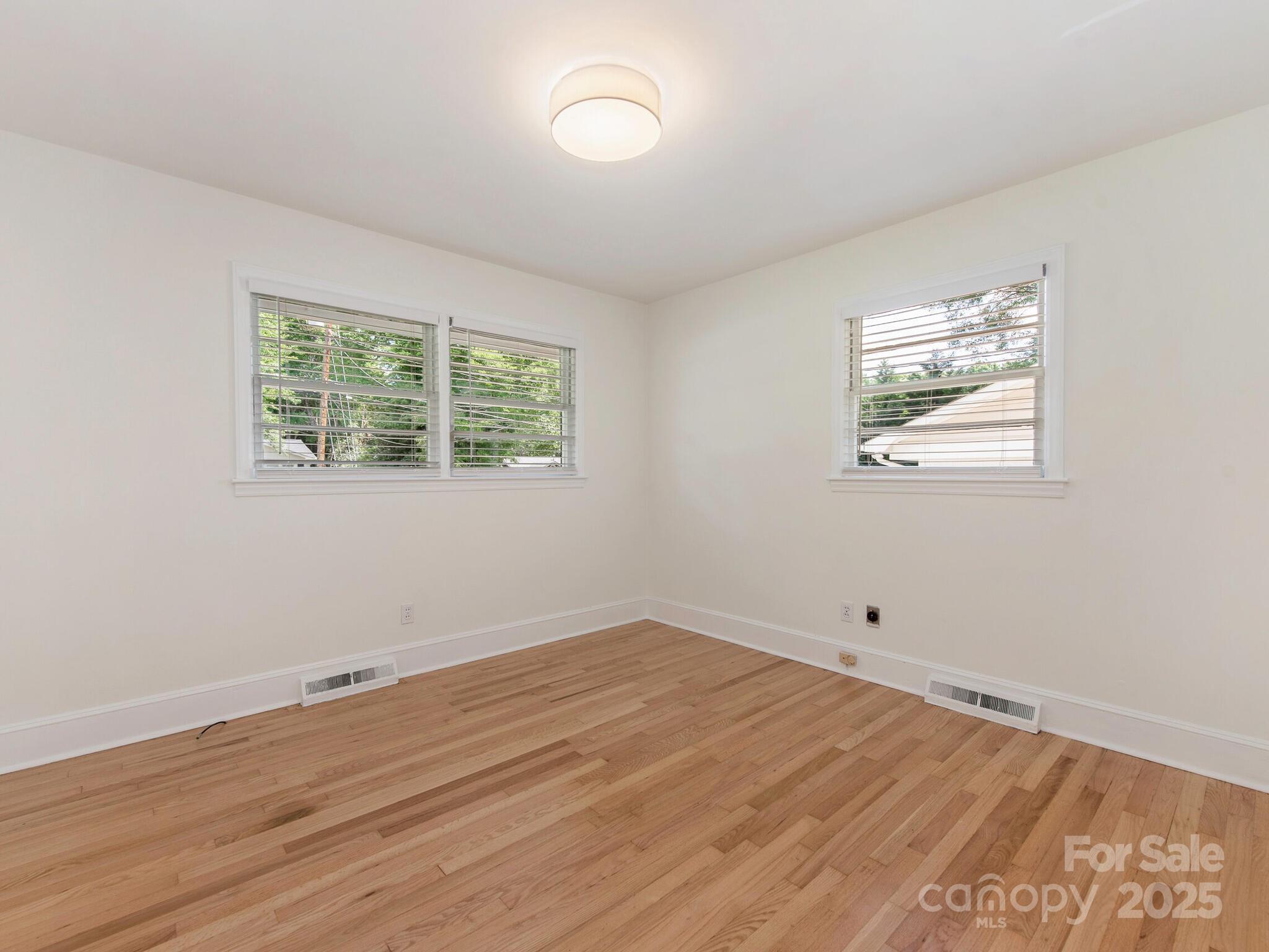 1422 Burnley Road Charlotte, NC 28210 - Photo 16 of 29 an empty room with wooden floor and windows