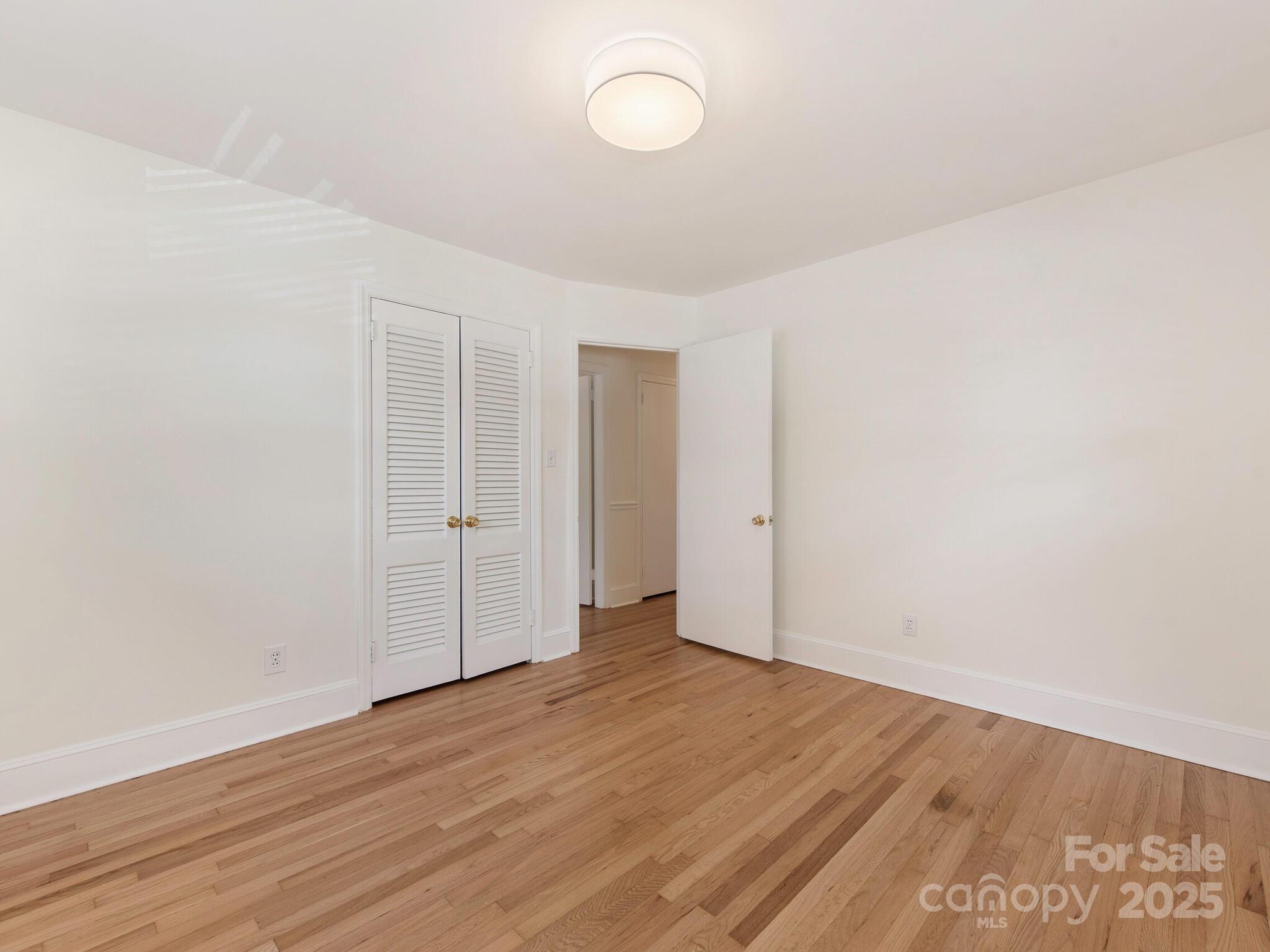 1422 Burnley Road Charlotte, NC 28210 - Photo 17 of 29 an empty room with wooden floor and windows