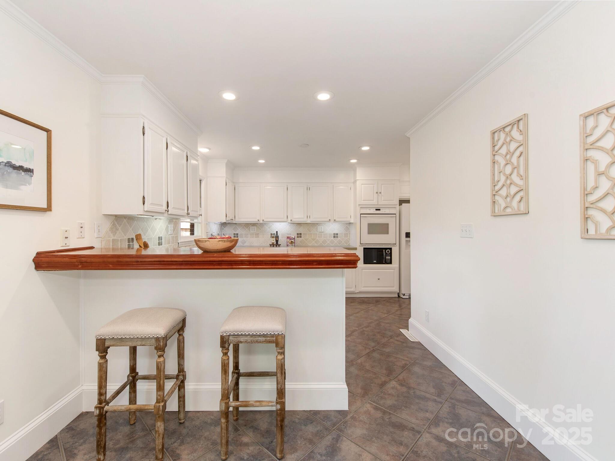 1422 Burnley Road Charlotte, NC 28210 - Photo 8 of 29 a kitchen with stainless steel appliances granite countertop a table chairs refrigerator and sink