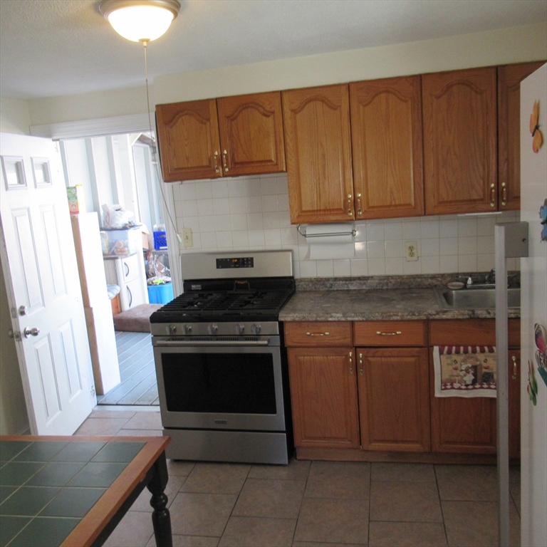 29 Villa Avenue Everett, MA 02149 - Photo 9 of 16 a kitchen with stainless steel appliances granite countertop a stove a sink and a microwave
