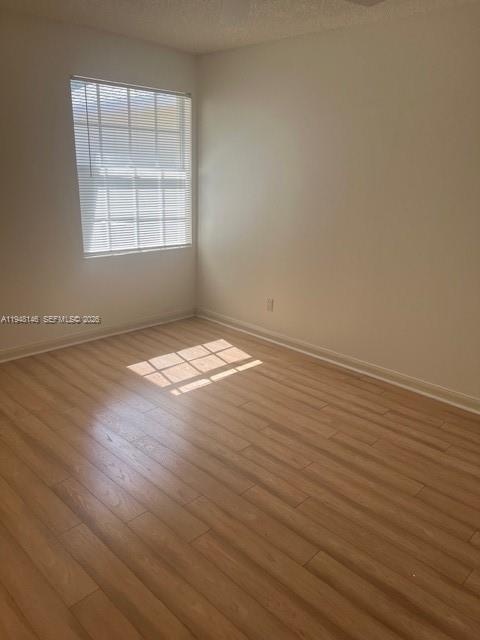 135 Brier Circle Jupiter, FL 33458 - Photo 12 of 14 an empty room with wooden floor and windows