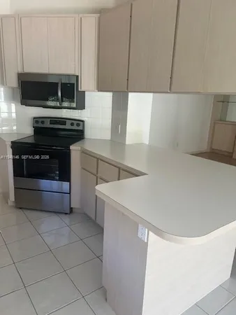 a kitchen with a sink a stove and cabinets