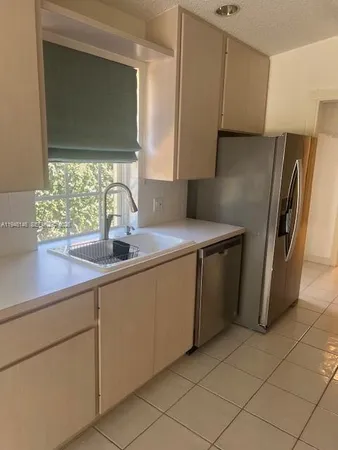 a kitchen with stainless steel appliances a sink and a refrigerator