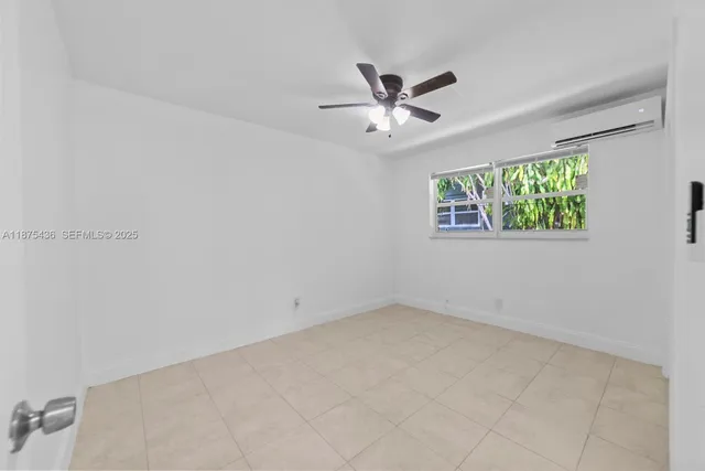 an empty room with windows and ceiling fan