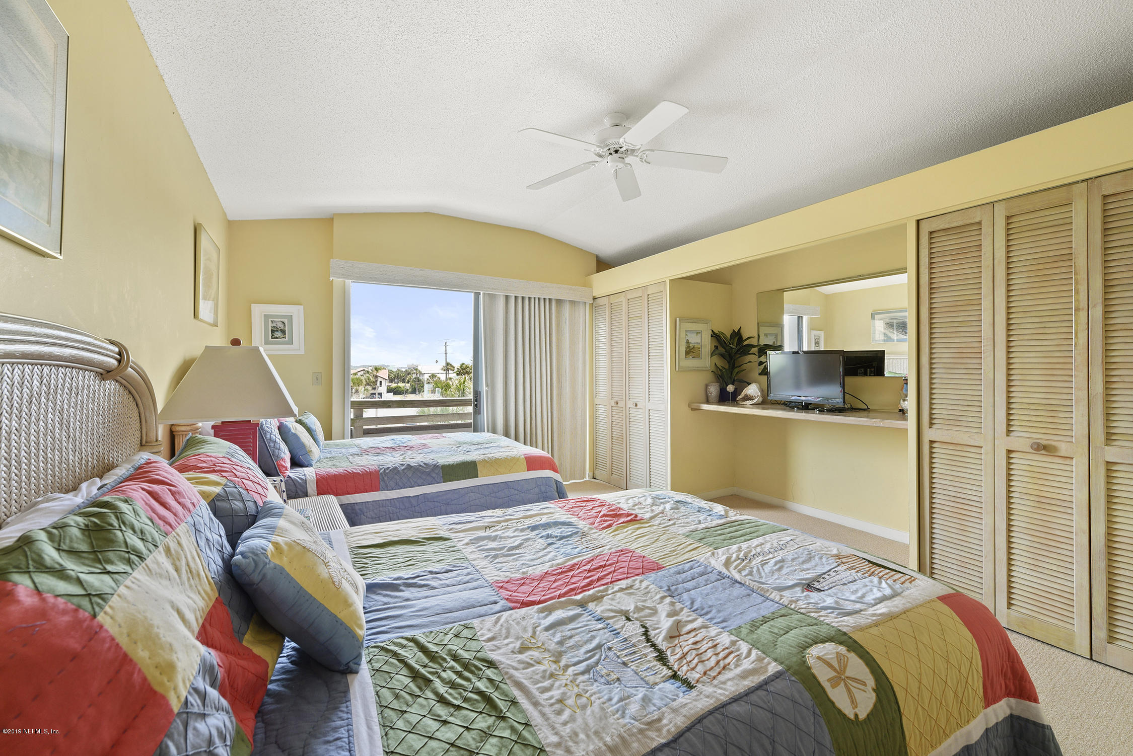 8850 Old A1A, Unit 9 St. Augustine, FL 32080 - Photo 26 of 37 a bedroom with a bed and a chandelier