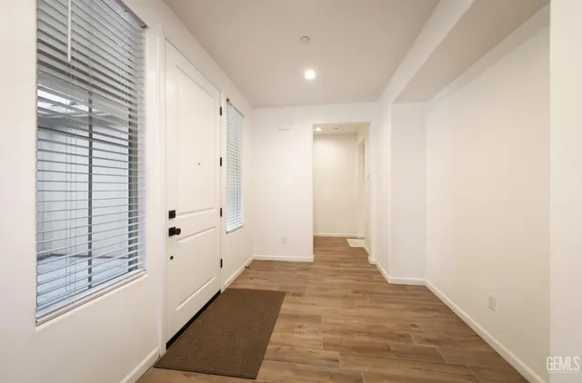 a view of a hallway with wooden floor and staircase