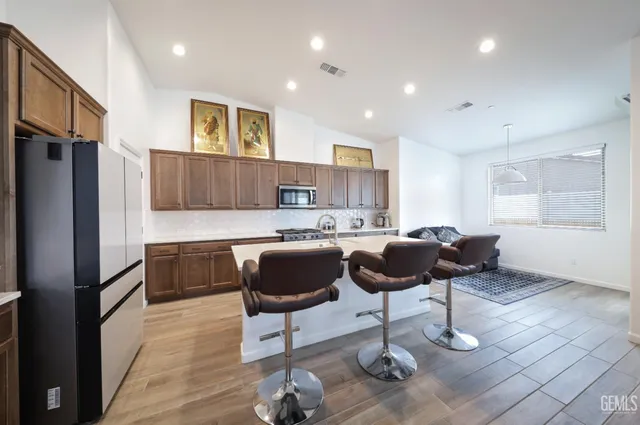 a kitchen with granite countertop a refrigerator and a stove top oven
