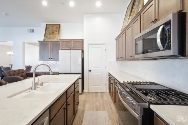 a kitchen with stainless steel appliances granite countertop a sink stove and cabinets