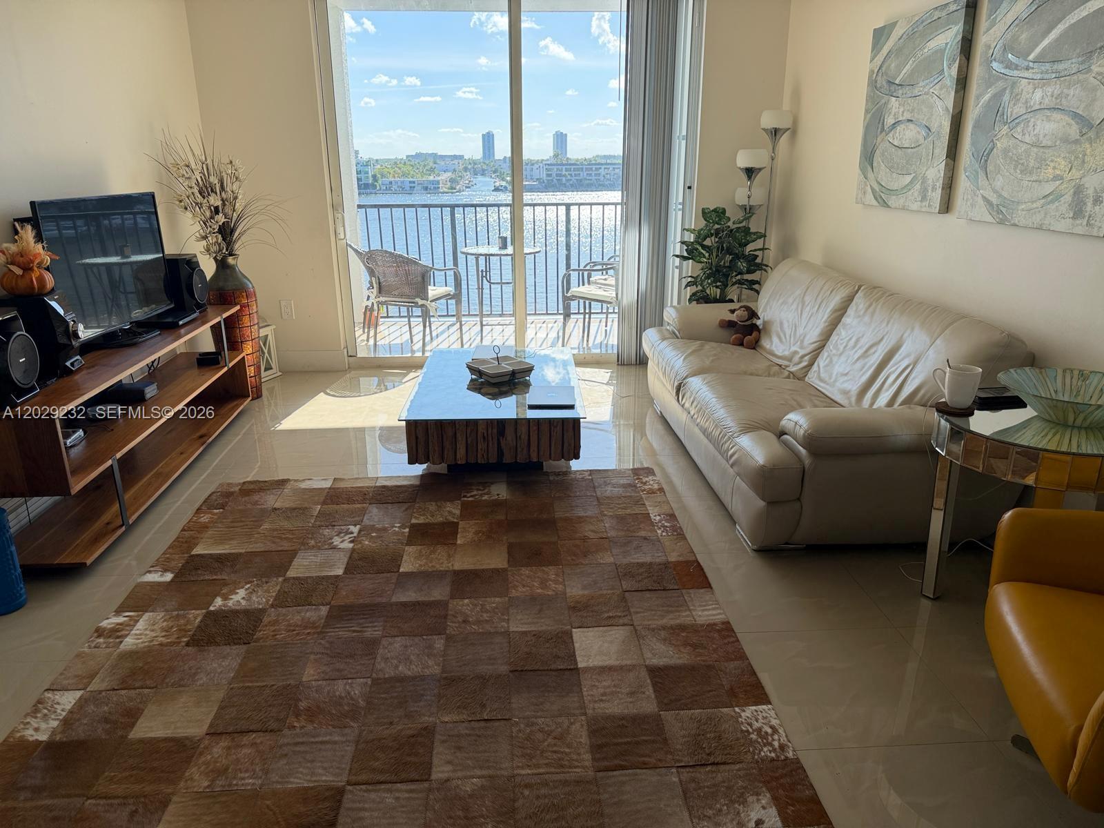 17100 North Bay Road, Unit 1605 Sunny Isles Beach, FL 33160 - Photo 1 of 52 a living room with furniture and a floor to ceiling window