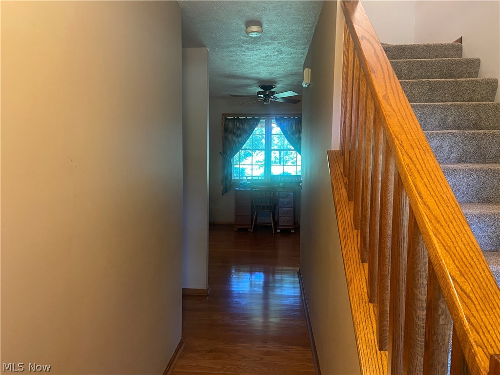2445 South Elyria Road Wooster, OH 44691 - Photo 20 of 46 Hall with wood finished floors, a textured ceiling, and stairway