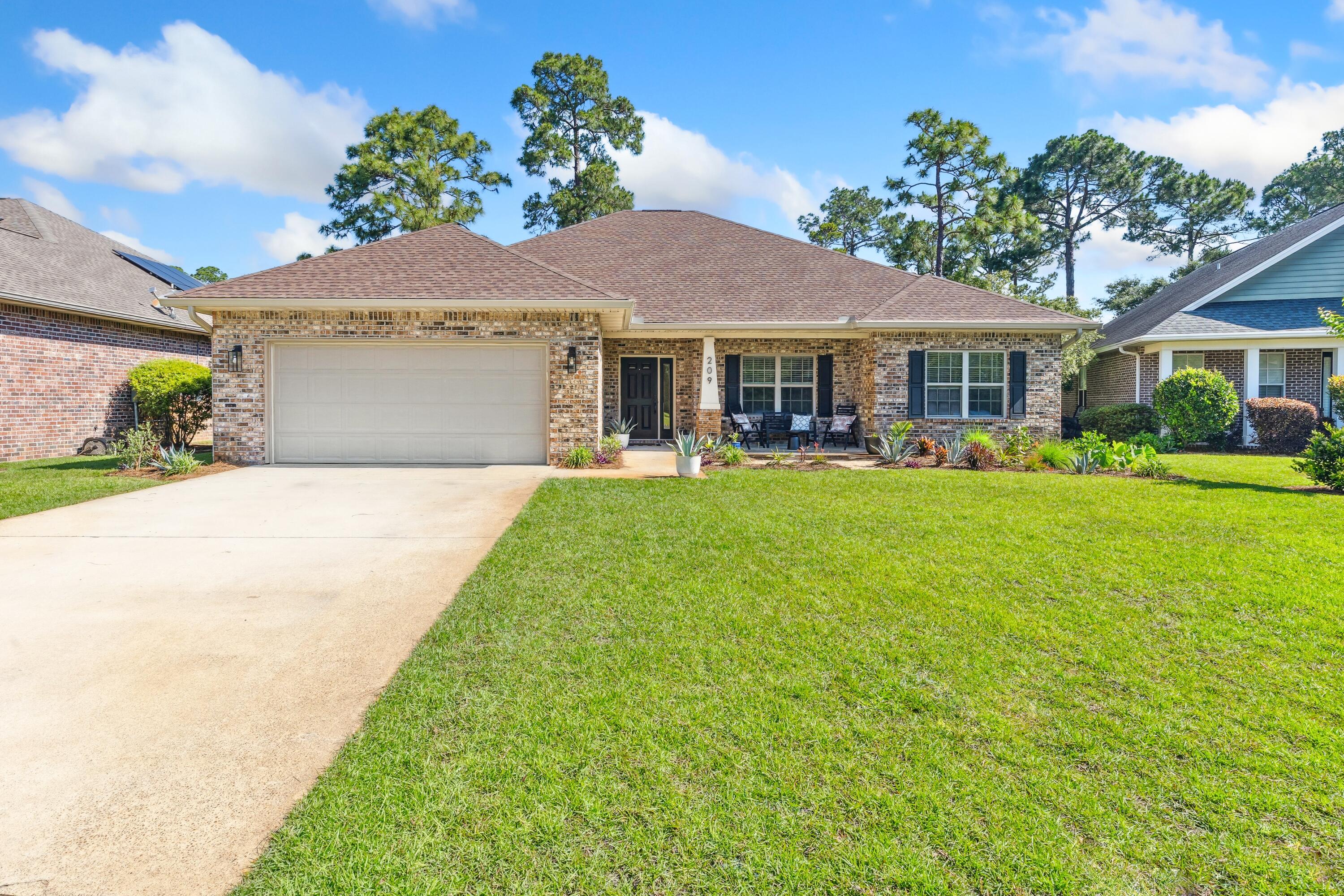 209 Forest Park Drive Santa Rosa Beach, FL 32459 - Photo 1 of 49 a front view of a house with a garden and plants