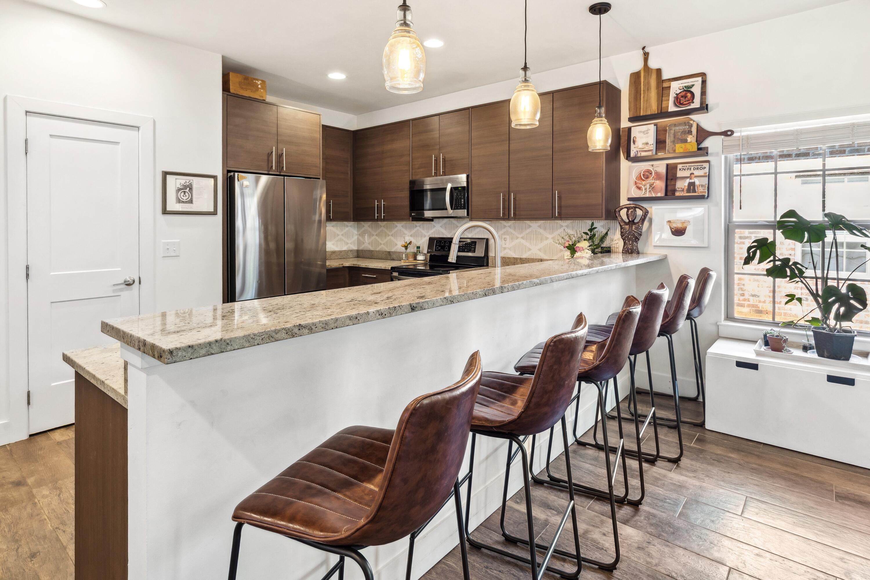 209 Forest Park Drive Santa Rosa Beach, FL 32459 - Photo 10 of 49 a kitchen with stainless steel appliances kitchen island granite countertop a table chairs refrigerator and microwave