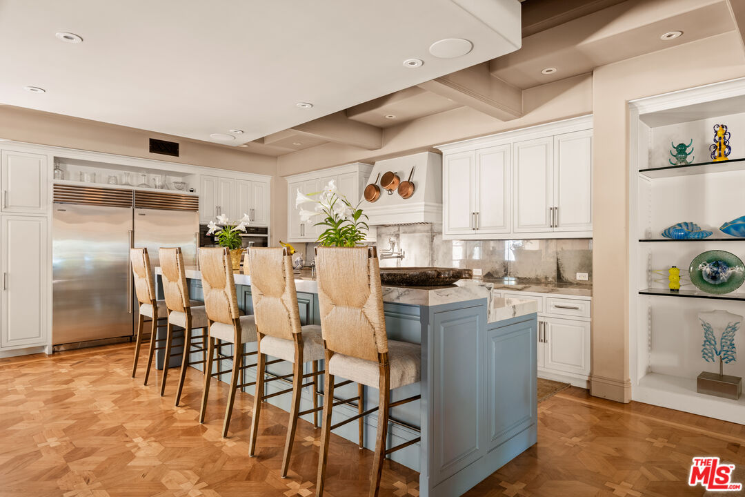 4009 Valley Meadow Road Encino, CA 91436 - Photo 11 of 32 a kitchen with a table chairs refrigerator and cabinets