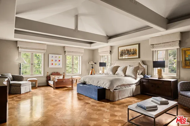 a bedroom with a large bed couch and a large window