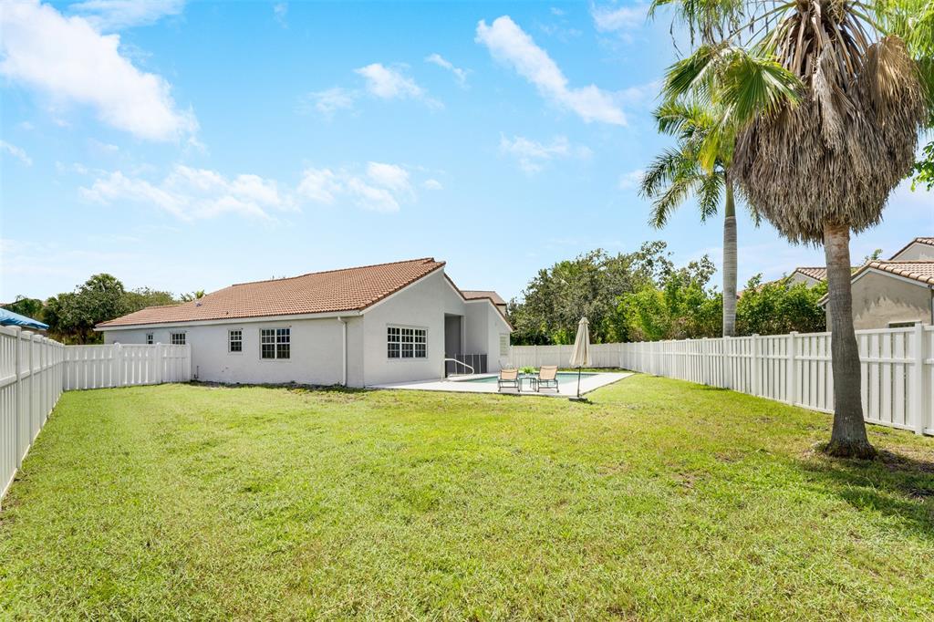 558 Slippery Rock Road Weston, FL 33327 - Photo 18 of 28 a view of a house with a swimming pool and a yard