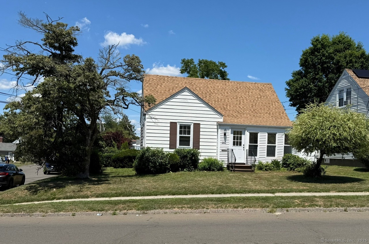 a view of a house with a yard and potted plants