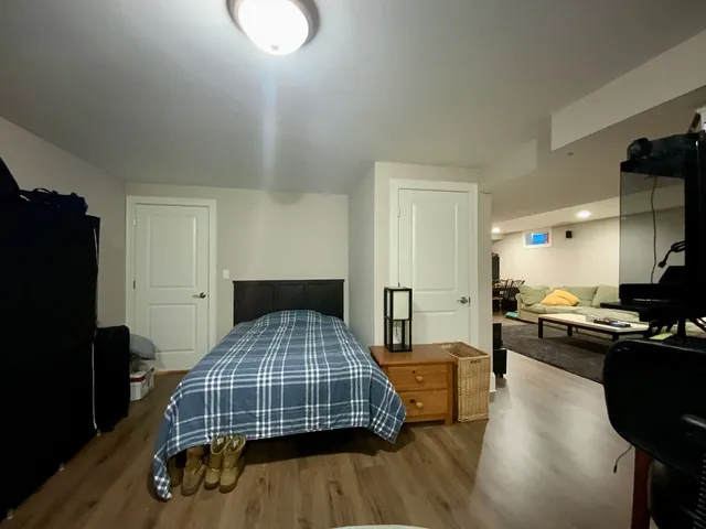 a bedroom with a bed and wooden floor