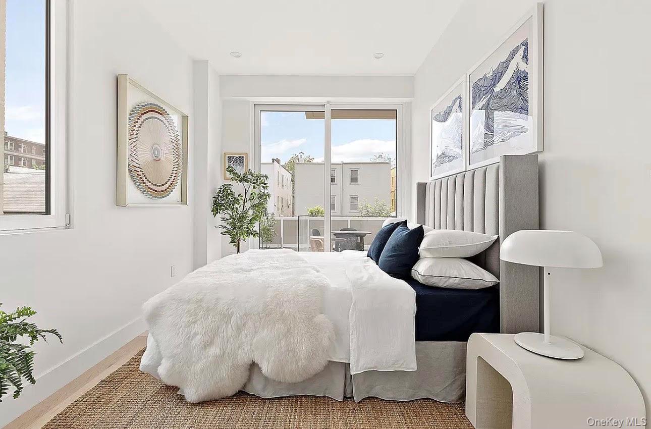 19-14 21st Road, Unit 2A Queens, NY 11105 - Photo 1 of 19 a bedroom with a bed and glass windows