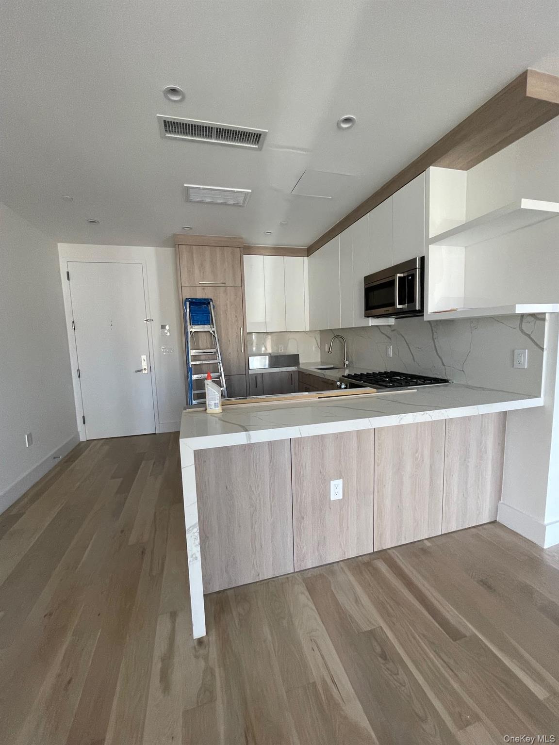 19-14 21st Road, Unit 2A Queens, NY 11105 - Photo 11 of 19 a kitchen with stainless steel appliances a refrigerator sink and microwave