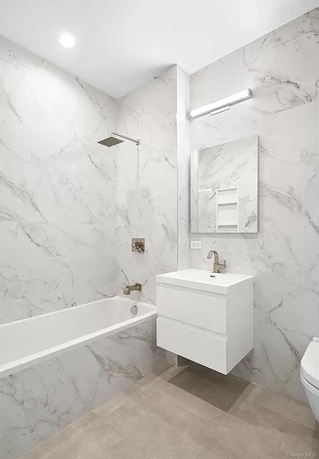 19-14 21st Road, Unit 2A Queens, NY 11105 - Photo 15 of 19 a bathroom with a sink a toilet and bathtub