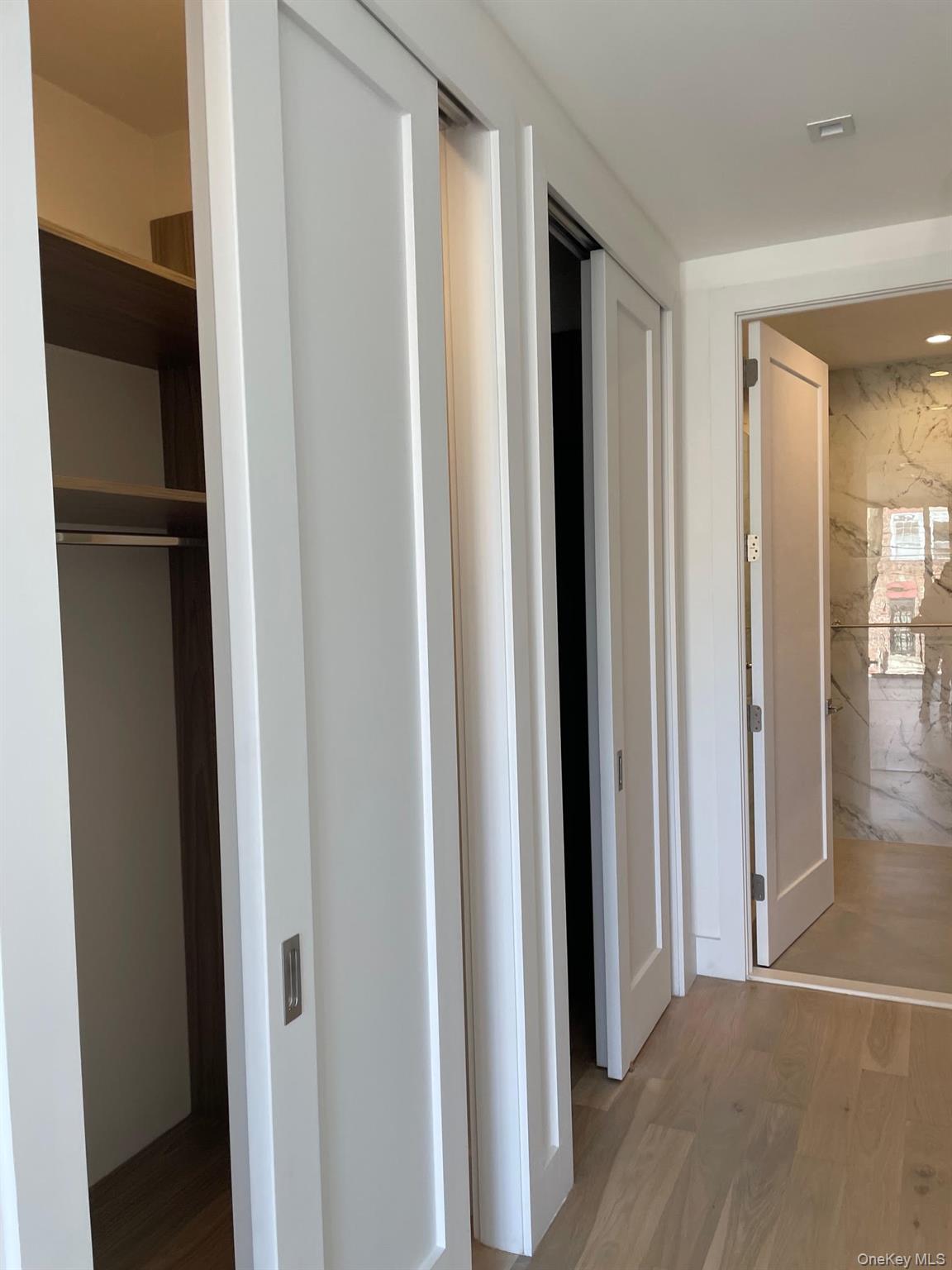 19-14 21st Road, Unit 2A Queens, NY 11105 - Photo 3 of 19 a view of closet area with wooden floor