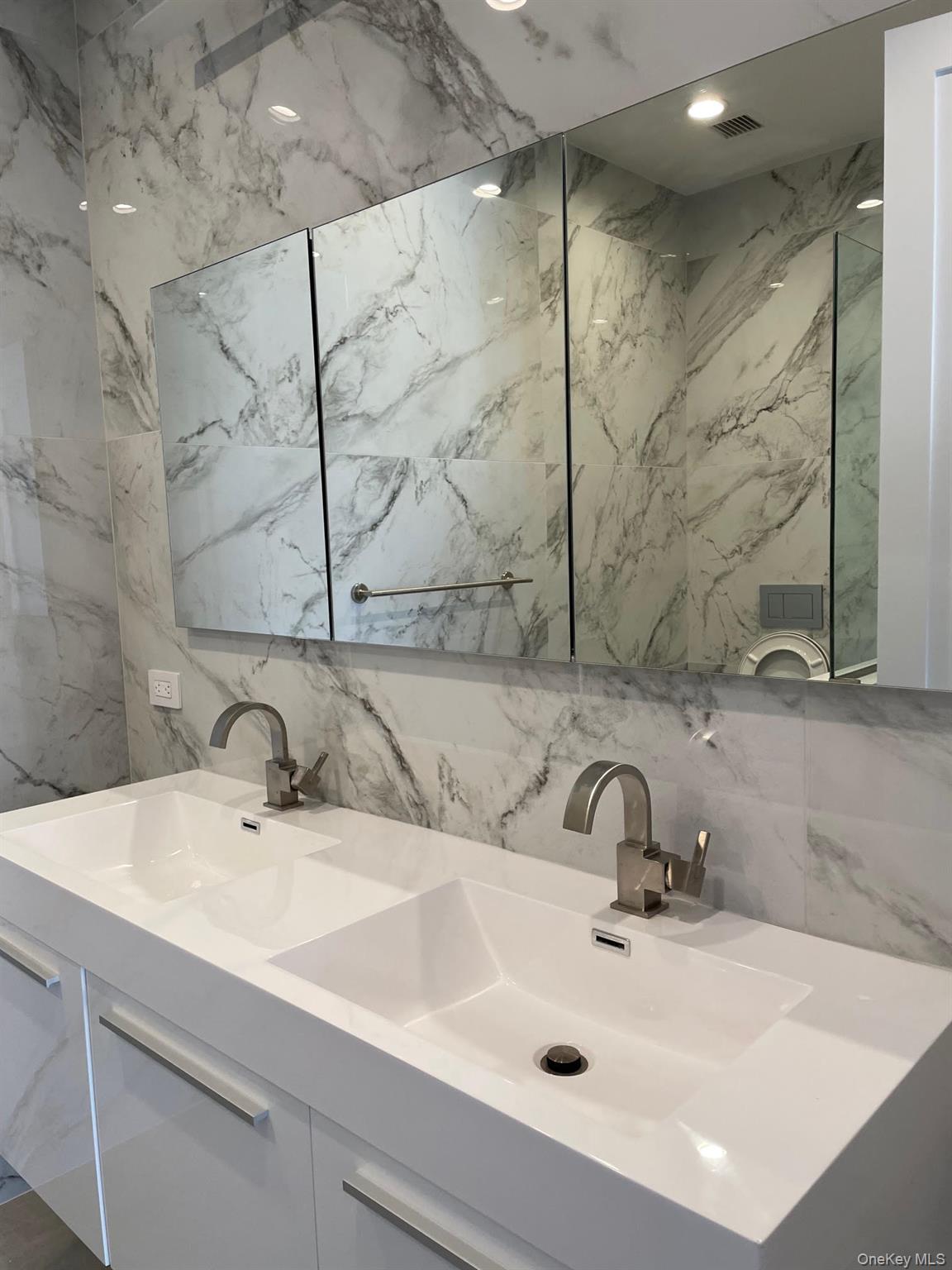 19-14 21st Road, Unit 2A Queens, NY 11105 - Photo 4 of 19 a bathroom with a sink and a mirror