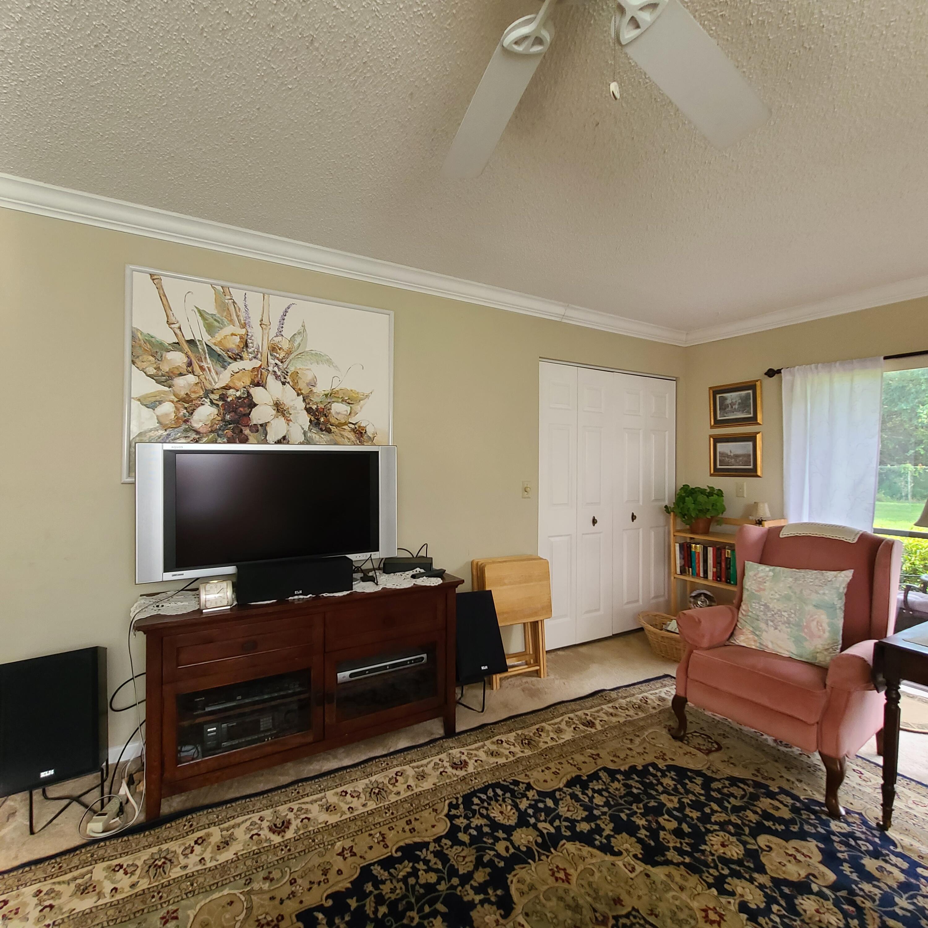 2975 Southwest 22nd Avenue, Unit 1080 Delray Beach, FL 33445 - Photo 28 of 67 a living room with furniture and a flat screen tv