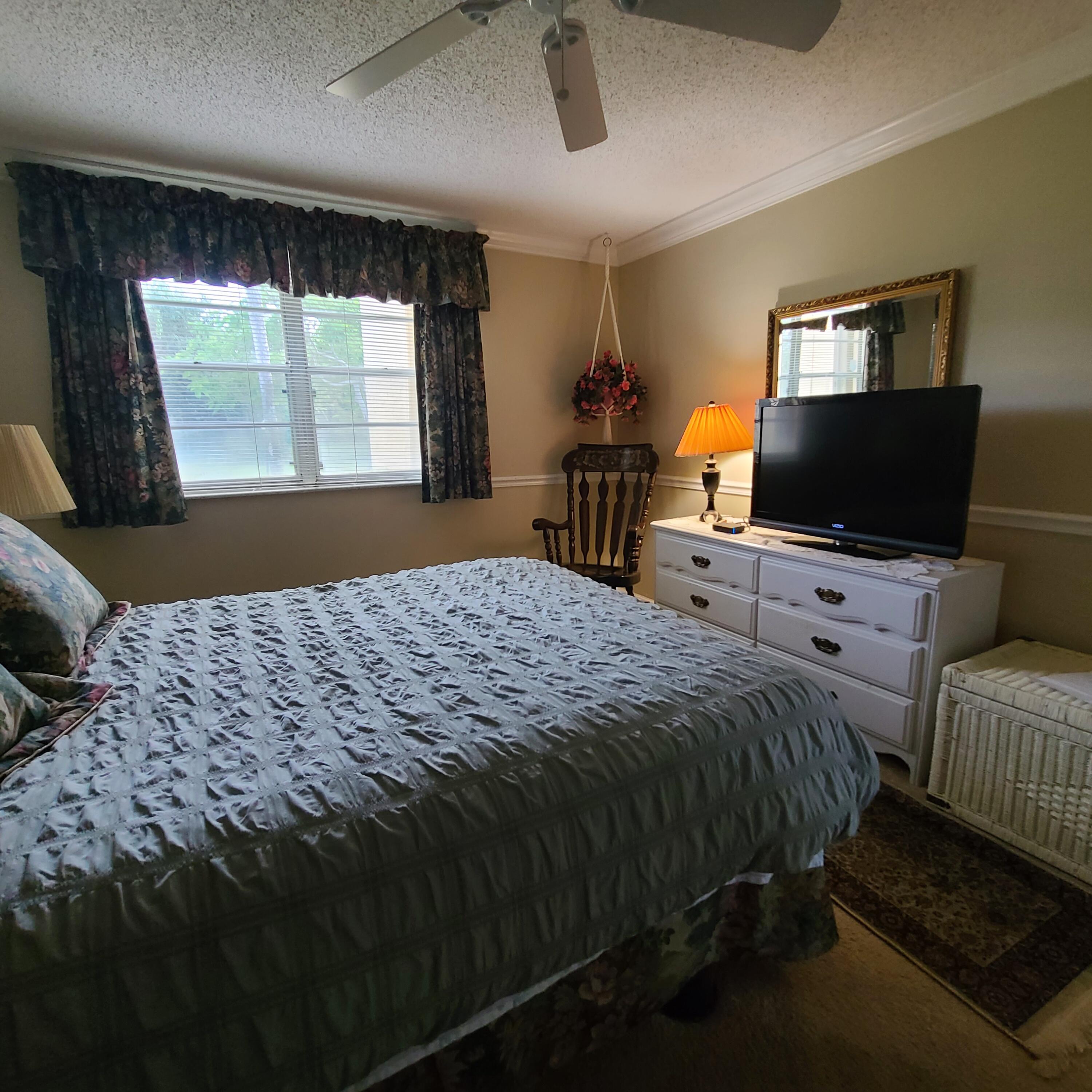 2975 Southwest 22nd Avenue, Unit 1080 Delray Beach, FL 33445 - Photo 33 of 67 a bedroom with a bed and glass windows