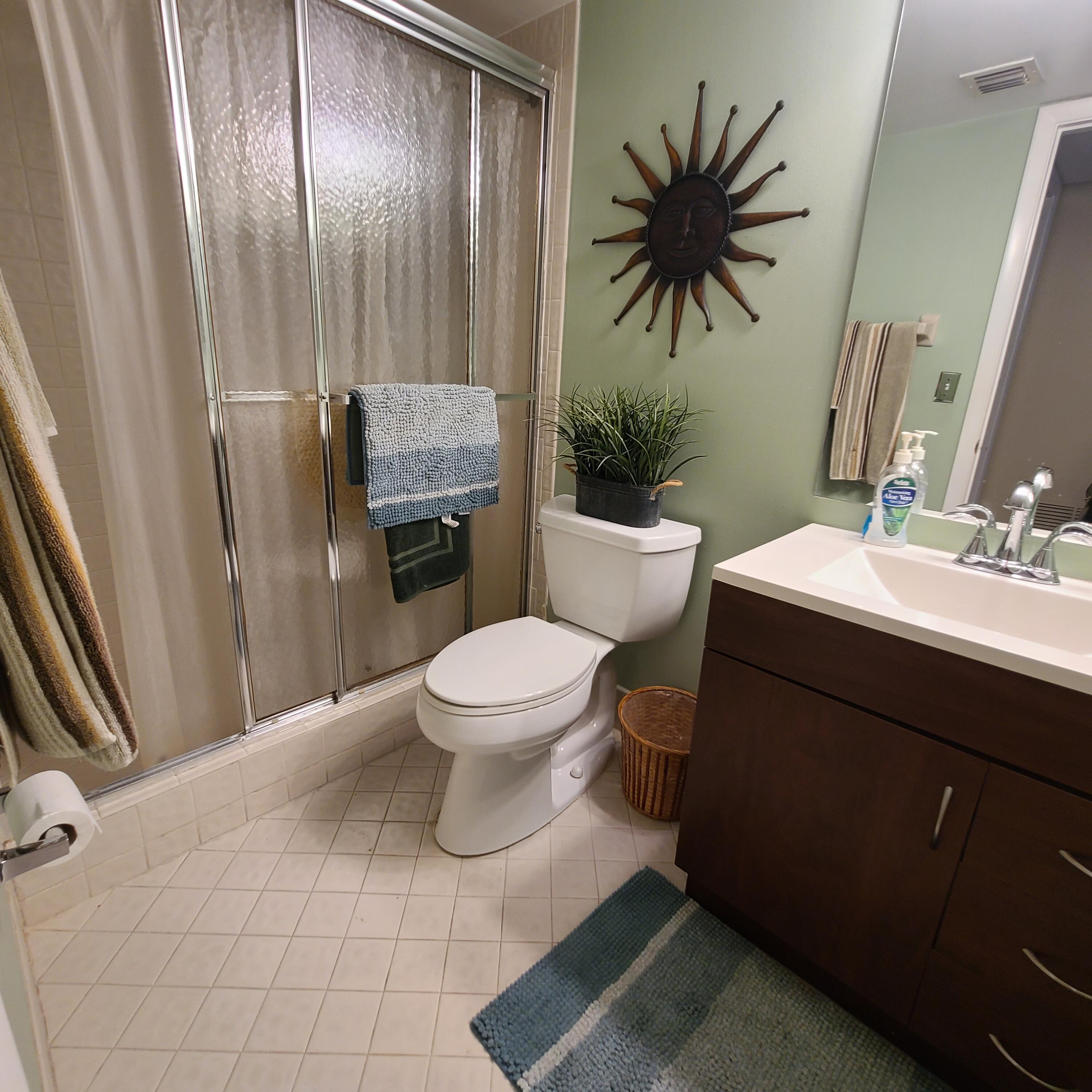 2975 Southwest 22nd Avenue, Unit 1080 Delray Beach, FL 33445 - Photo 36 of 67 a bathroom with a toilet sink and mirror