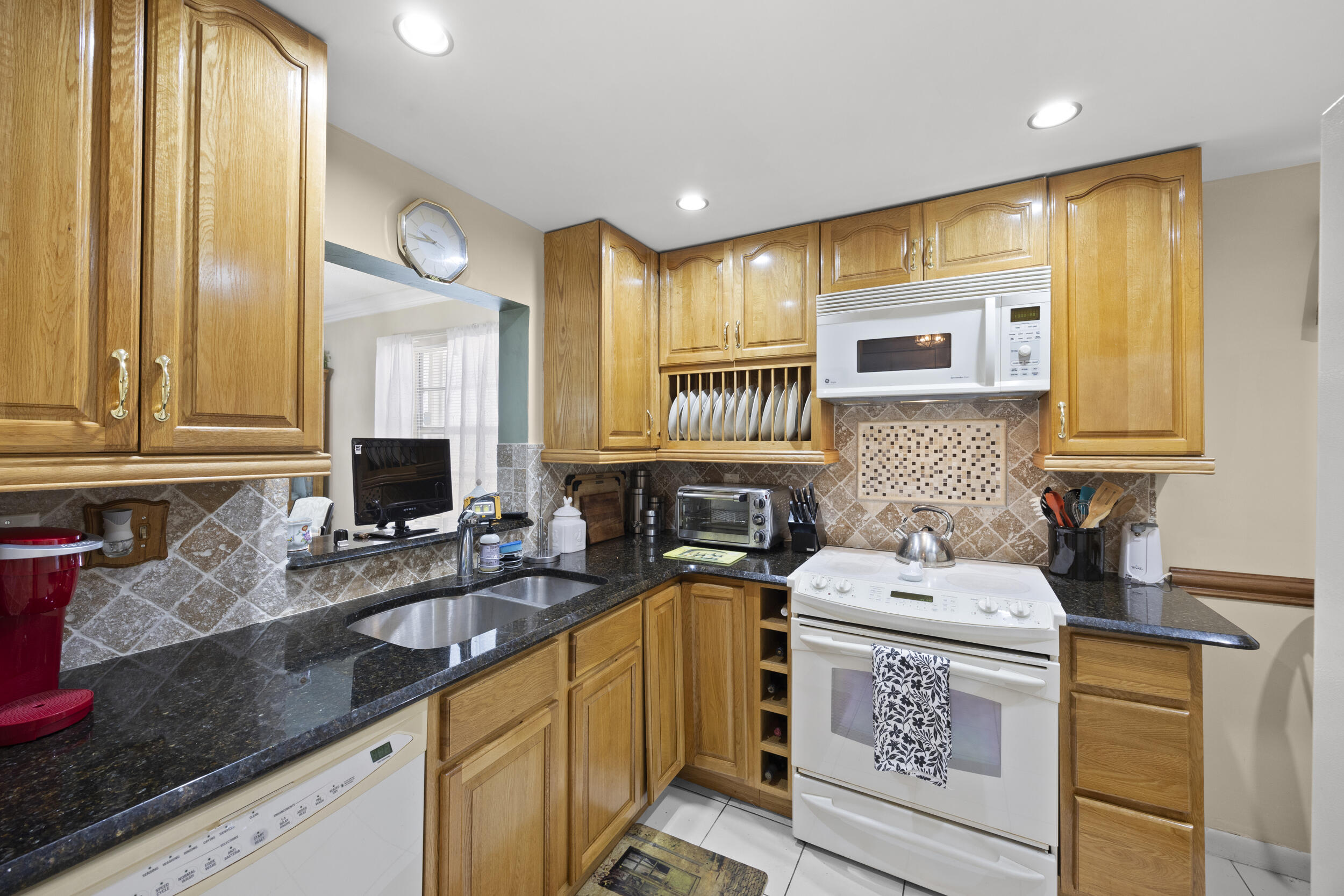 2975 Southwest 22nd Avenue, Unit 1080 Delray Beach, FL 33445 - Photo 6 of 67 a kitchen with a sink stove and cabinets