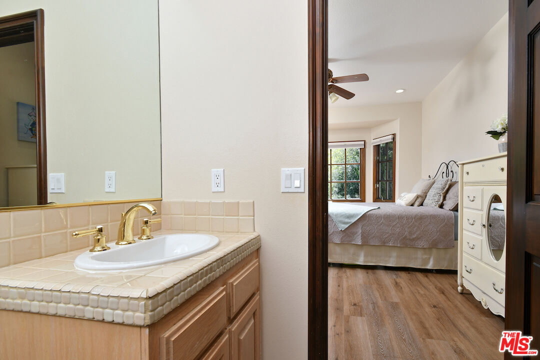 2317 Sierra Creek Road Agoura Hills, CA 91301 - Photo 33 of 73 a en suite bathroom with a granite countertop sink and a mirror