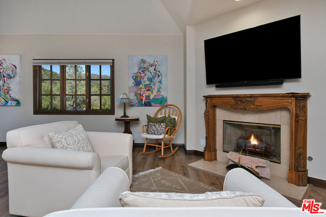 2317 Sierra Creek Road Agoura Hills, CA 91301 - Photo 42 of 73 a living room with furniture a flat screen tv and a fireplace