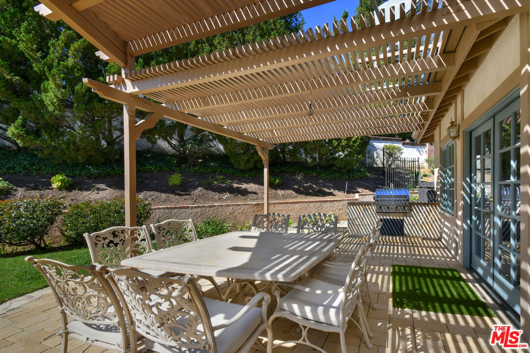 2317 Sierra Creek Road Agoura Hills, CA 91301 - Photo 48 of 73 a view of a patio with table and chairs with wooden floor and fence