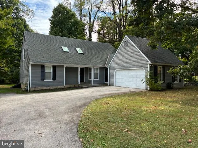 a front view of a house with yard and trees