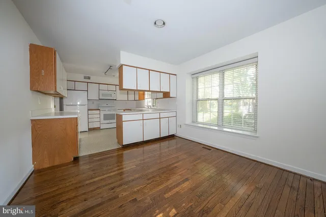 a view of a kitchen with cabinets and wooden floor