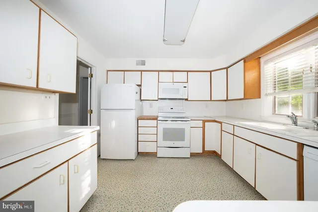 a kitchen with white cabinets and white appliances