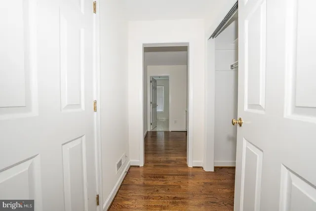 a view of a hallway with wooden floor