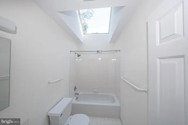a bathroom with a granite countertop bathtub shower sink vanity and toilet