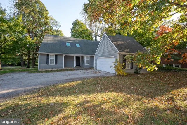 a view of a house with a yard and large tree