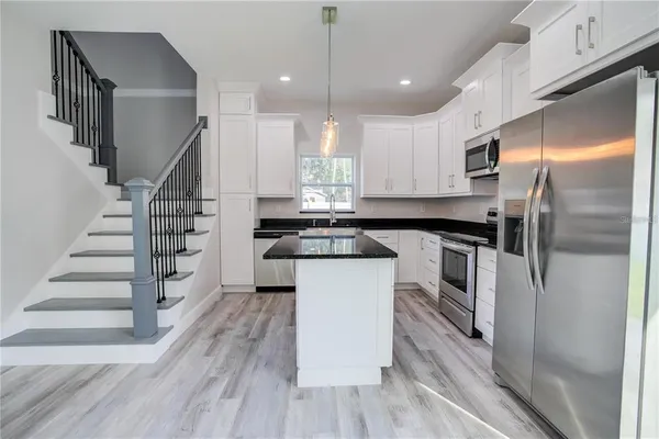 a kitchen with white cabinets and stainless steel appliances