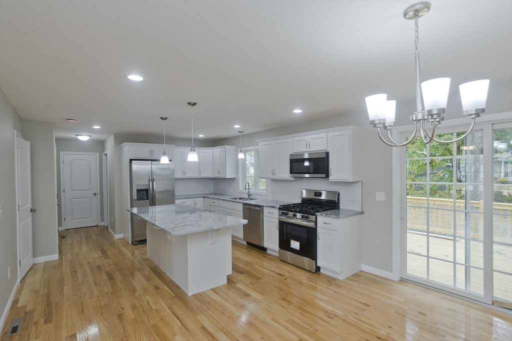 34 Chilson Street Springfield, MA 01118 - Photo 3 of 23 a kitchen with stainless steel appliances granite countertop a sink a stove and a wooden floors