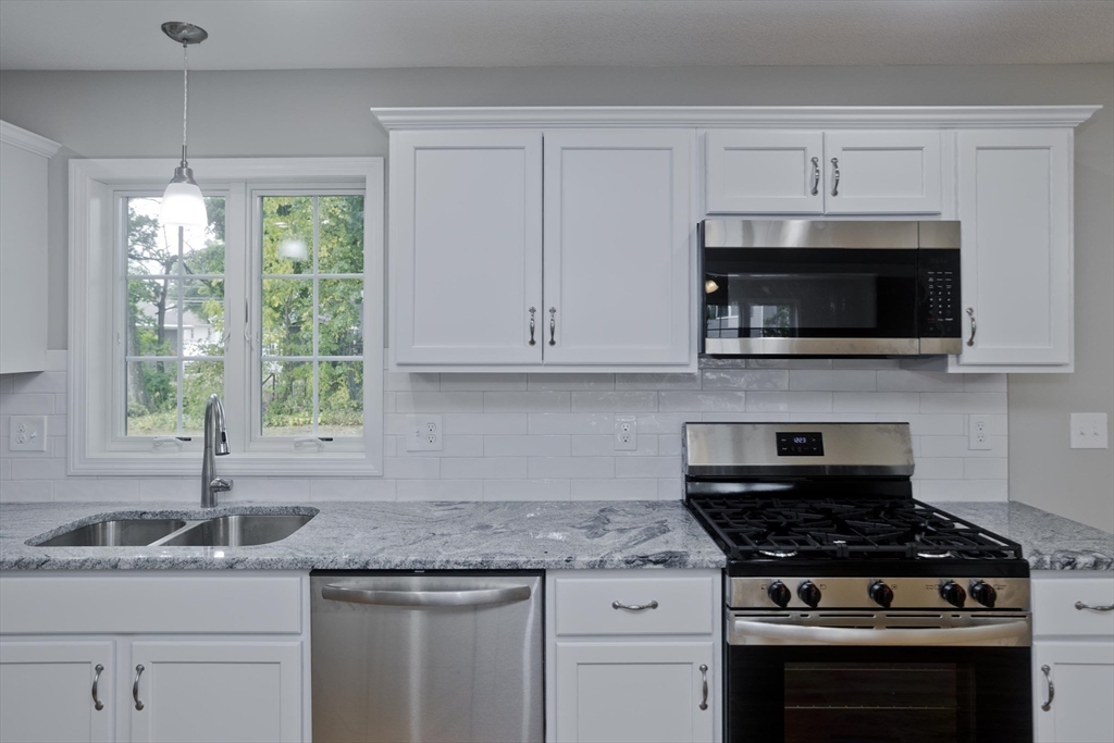 34 Chilson Street Springfield, MA 01118 - Photo 8 of 23 a kitchen with granite countertop white cabinets and window