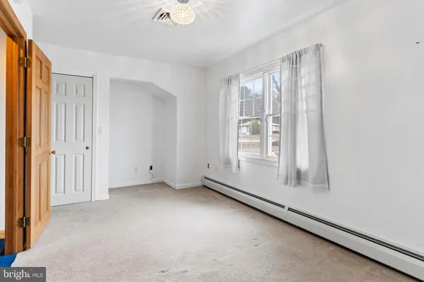 an empty room with windows and ceiling fan