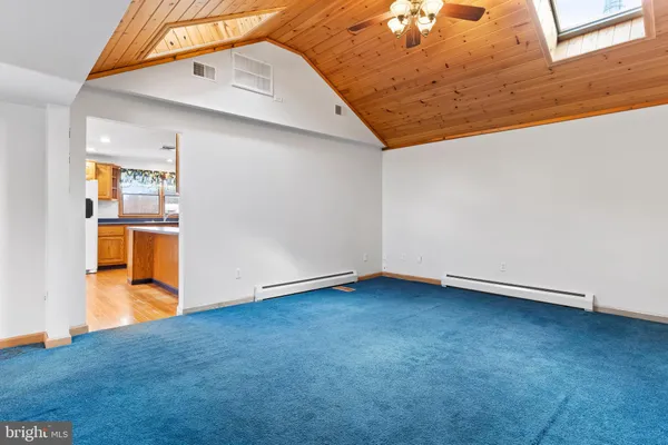 an empty room with wooden floor and hallway