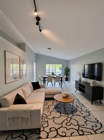 a living room with furniture a flat screen tv and a large window
