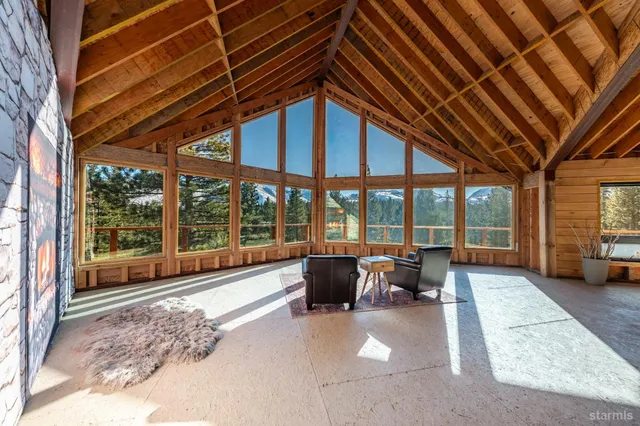 a view of a dining room with furniture large windows and wooden floor