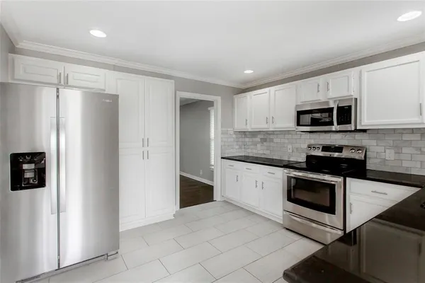 a kitchen with stainless steel appliances granite countertop a refrigerator microwave and sink