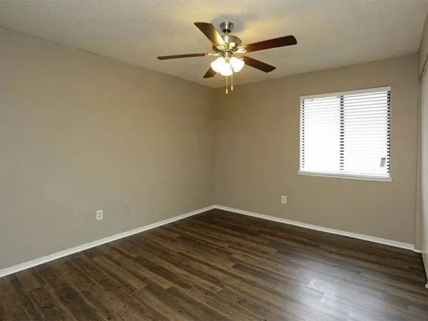 a view of a room with wooden floor and fan